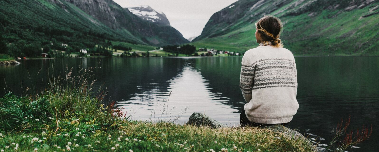 Frau am See und Berge im Hintergrund