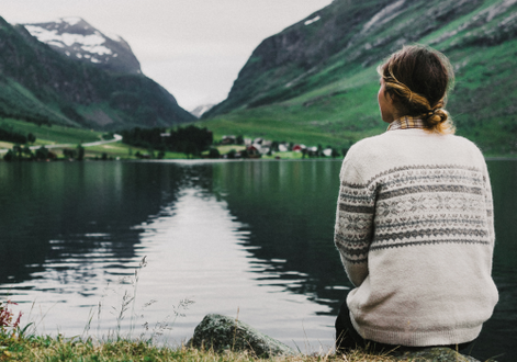 Frau am See und Berge im Hintergrund